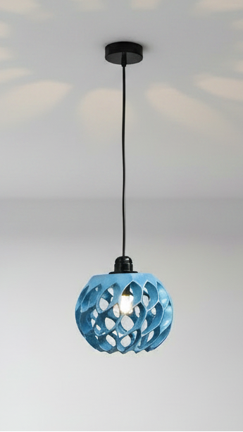A modern blue spherical pendant light with a geometric cutout pattern, suspended from a black ceiling canopy by a black cord against a white wall.